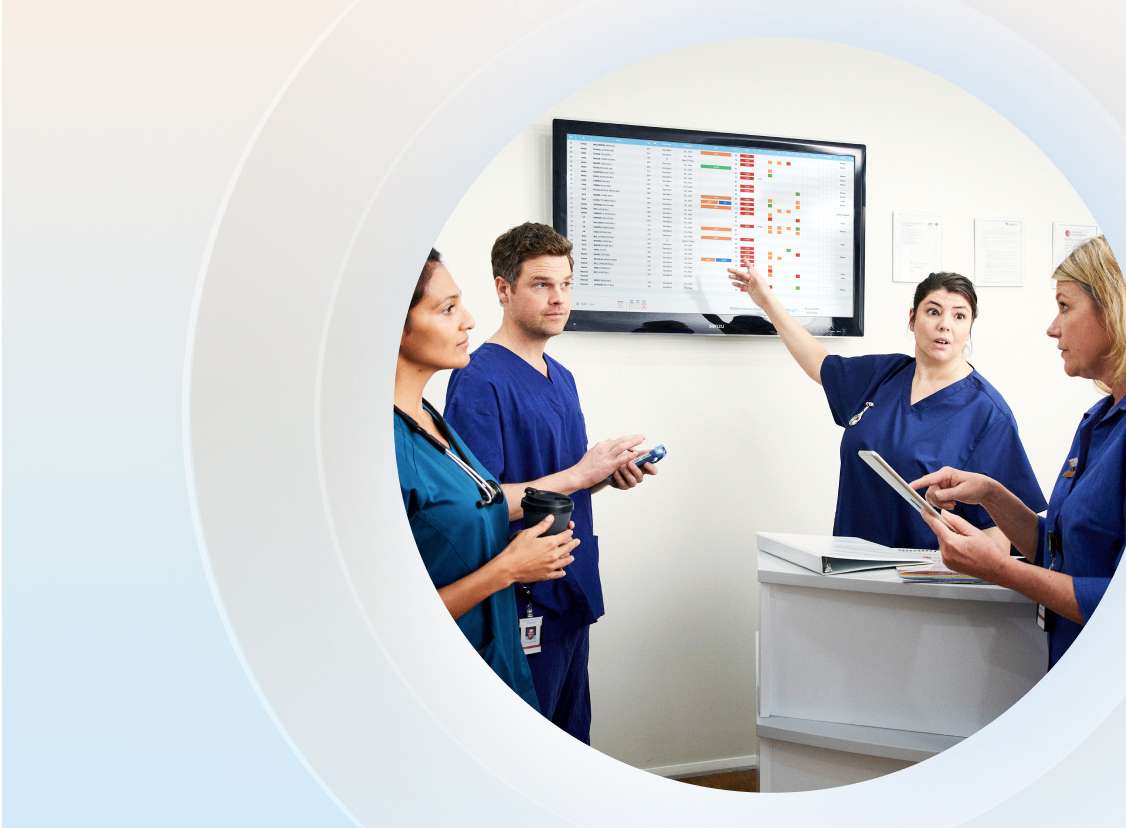 Nurses pointing at digital patient journey board