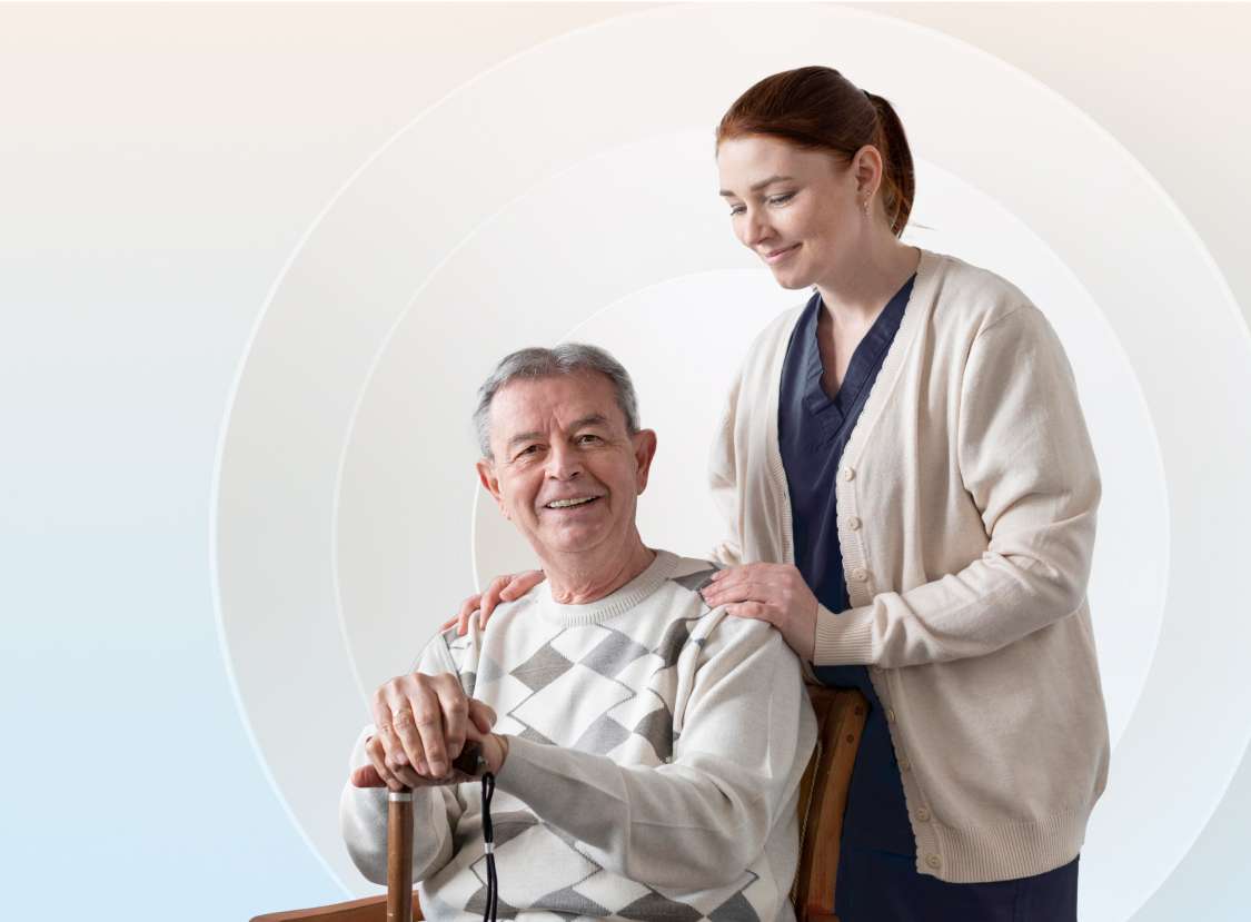 Aged care staff standing behind resident