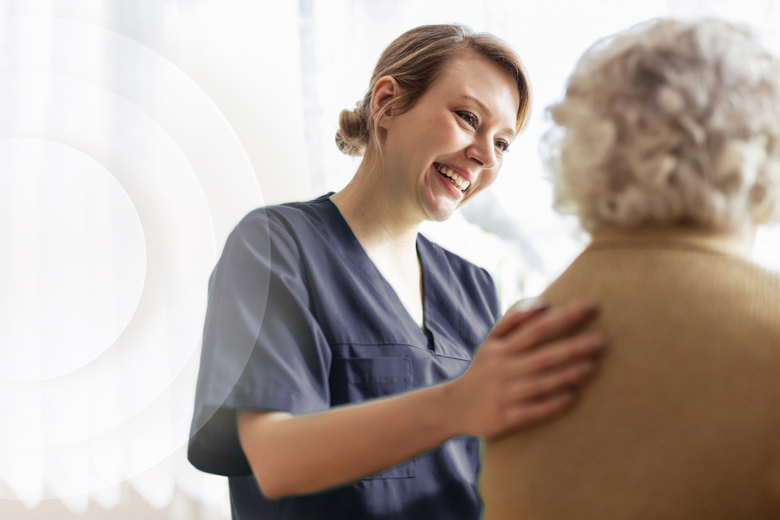 Nurse helping patient walk with hand on her back