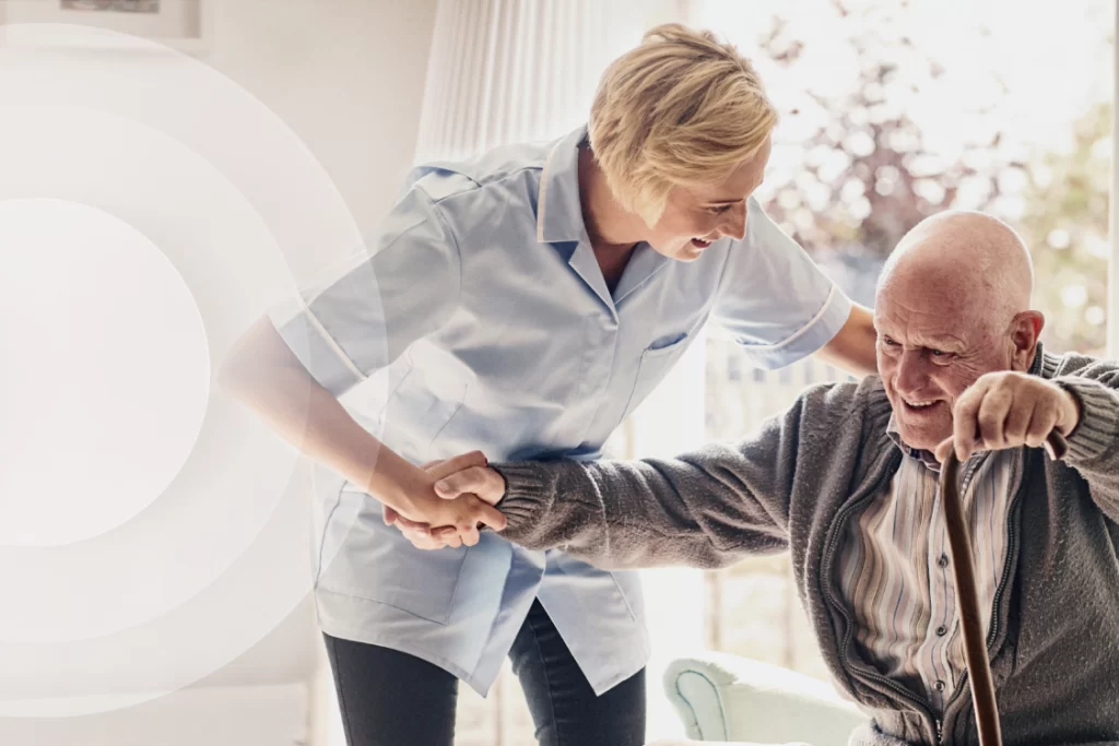 Aged care staff helping resident stand