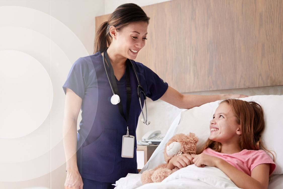 Nurse talking to young patient in hospital bed