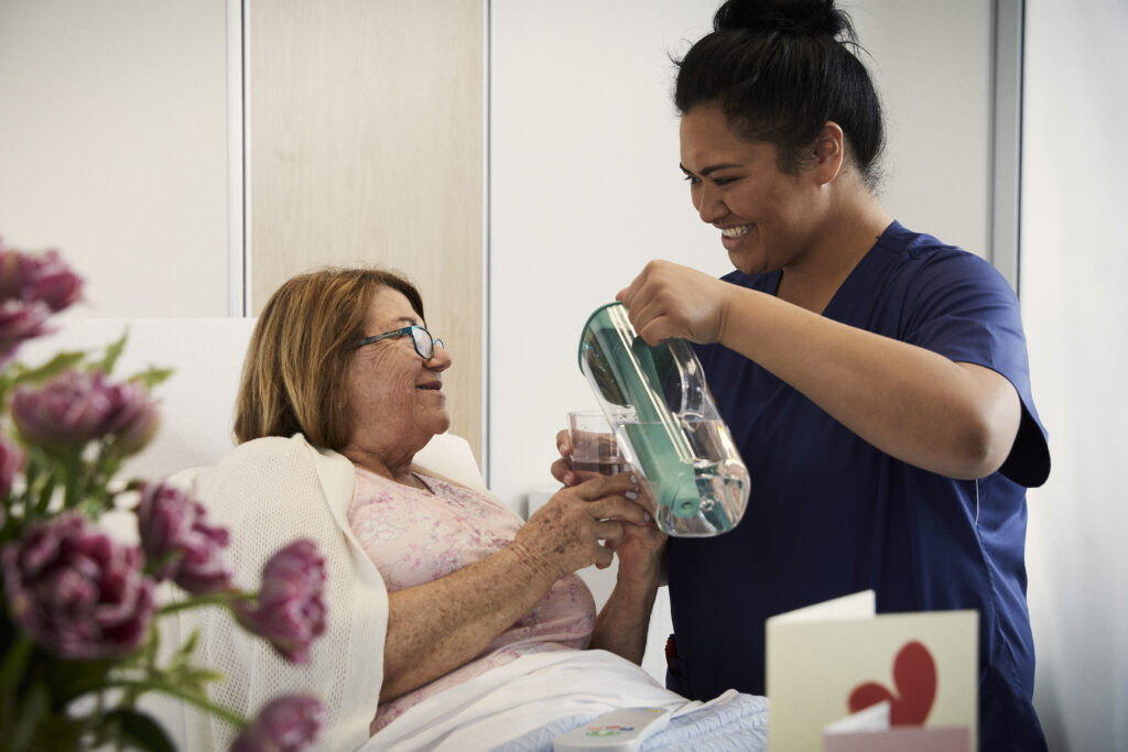 Female-Nurse-and-patient-Nurse-pooring-a-glass-of-water-for-patient